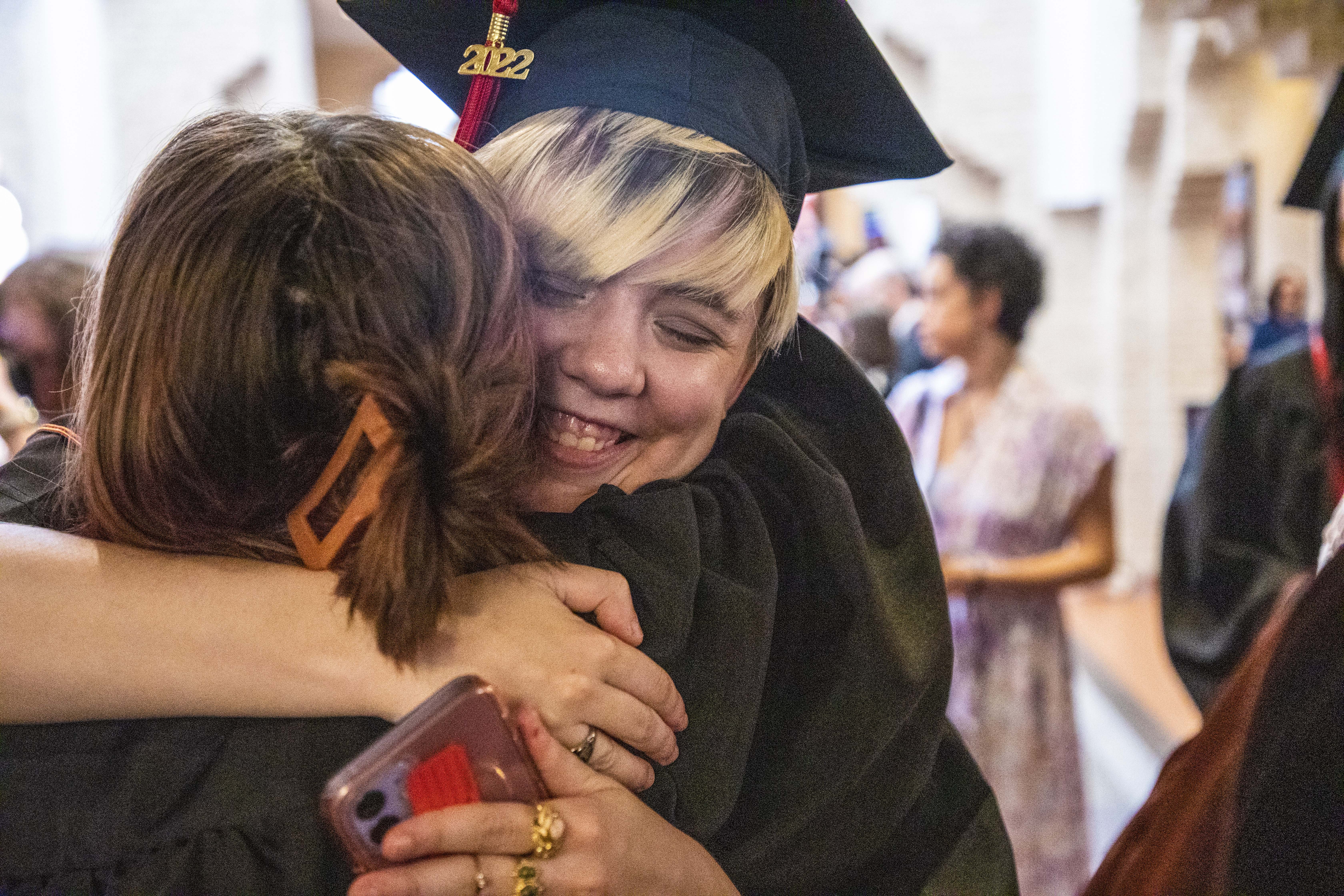 Moody College graduates exchange hugs.