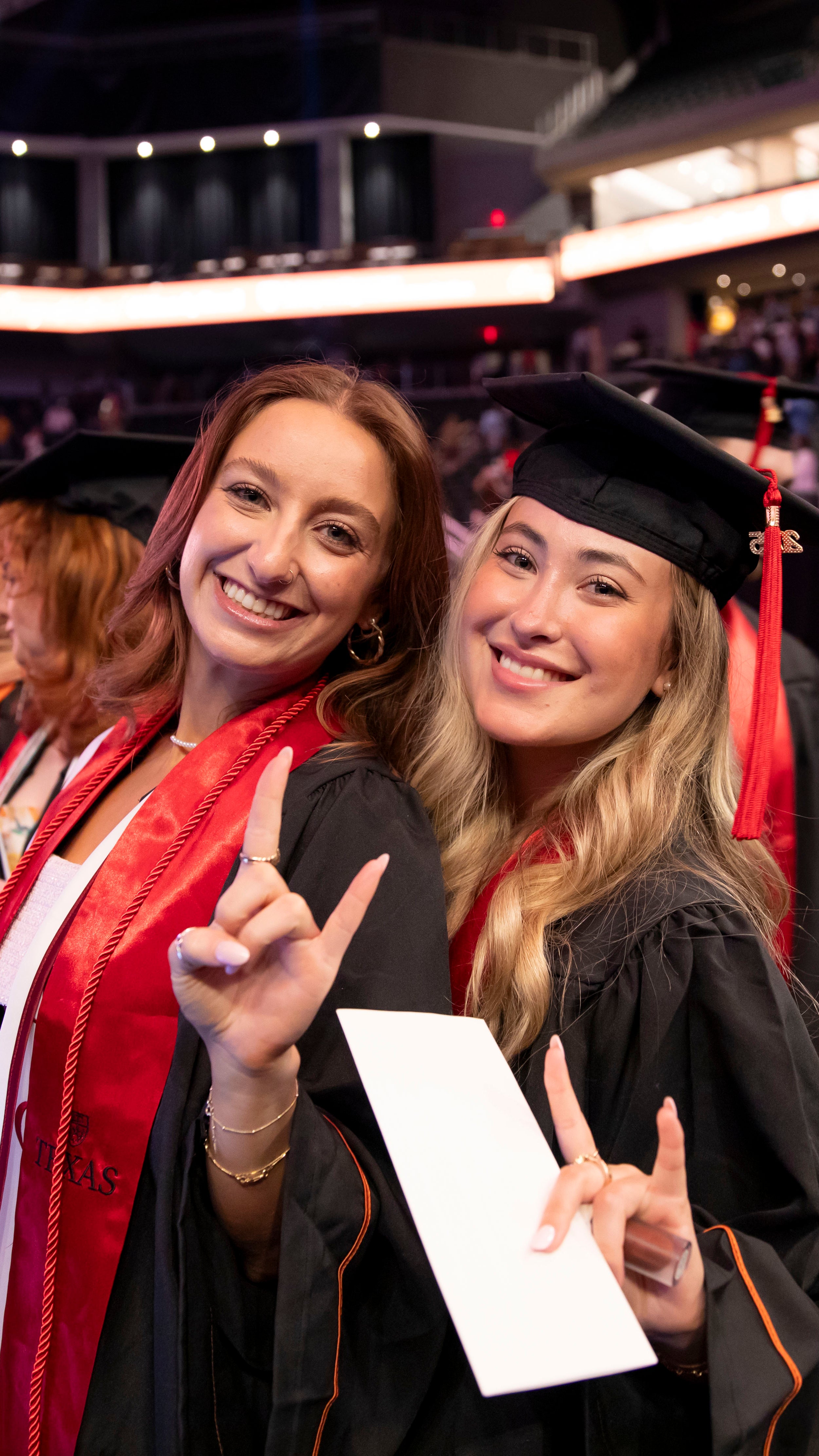 Moody students smiling with their diplomas at graduation