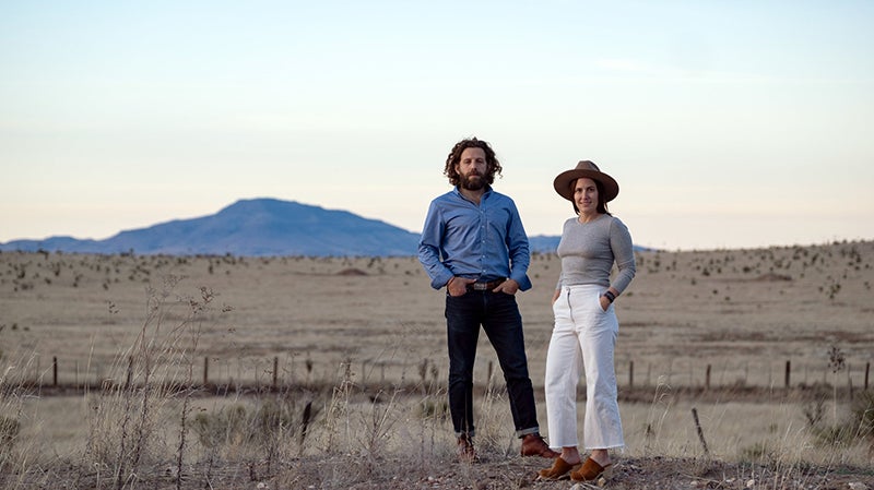 Maisie Crow and husband Max Kabat standing outside in West Texas, where they own a newspaper. 