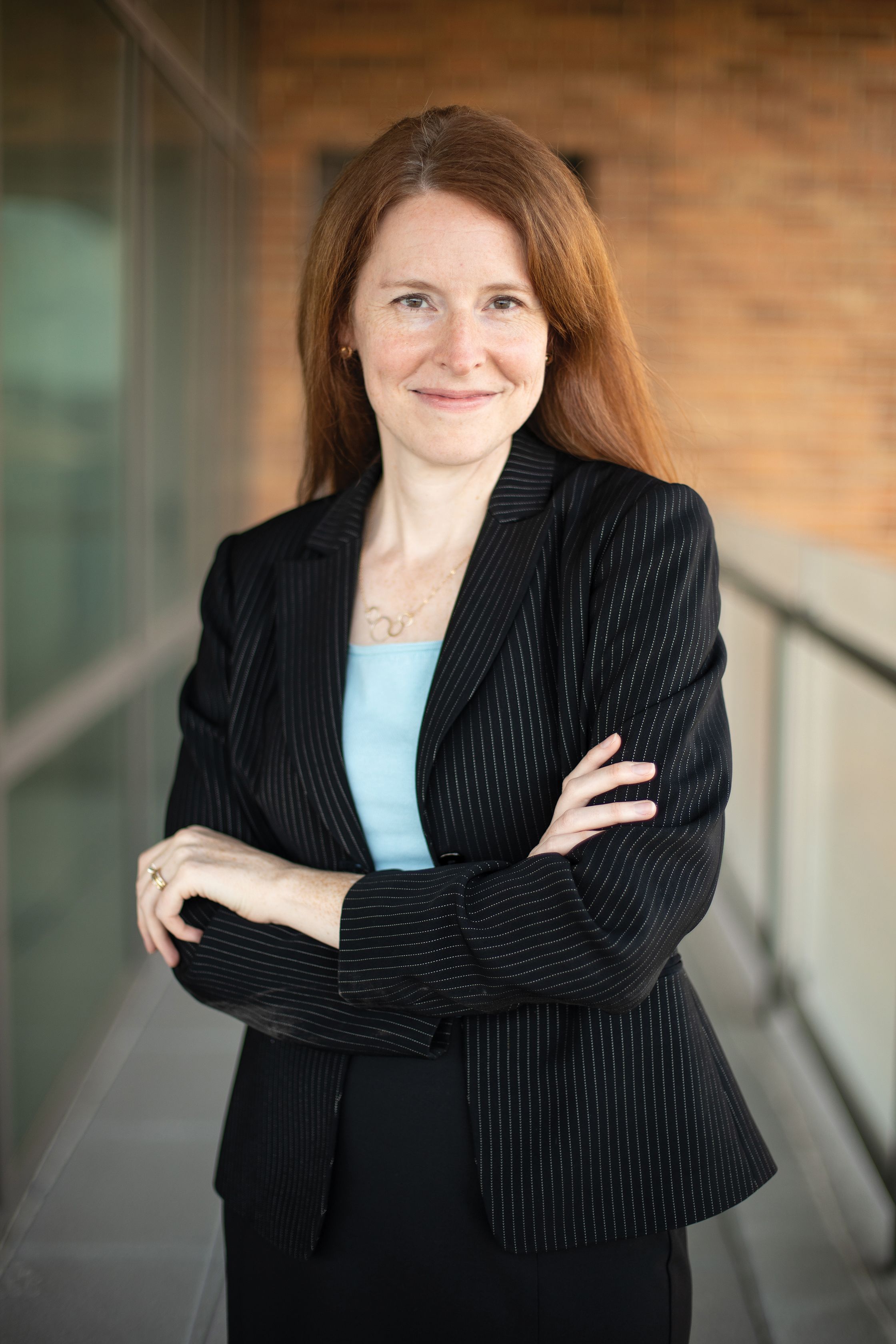professor talia stroud poses for a portrait outside with her arms crossed