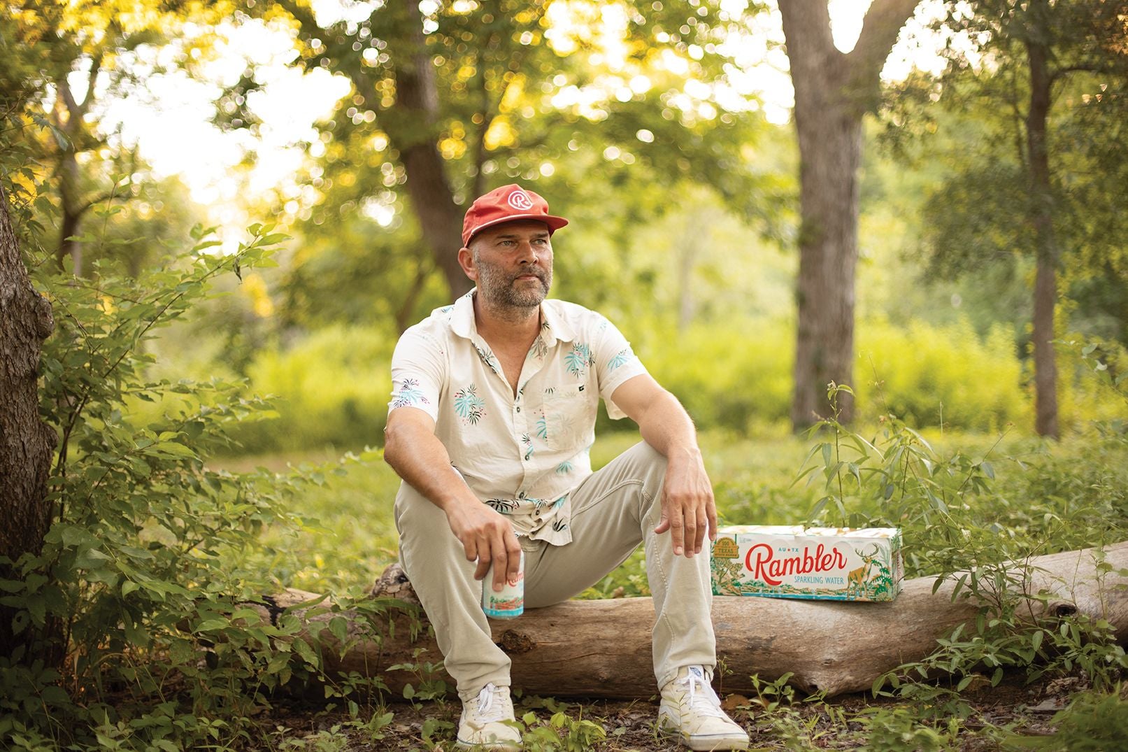 Moody College alum Dave Mead sitting on a log at mckinney roughs state park