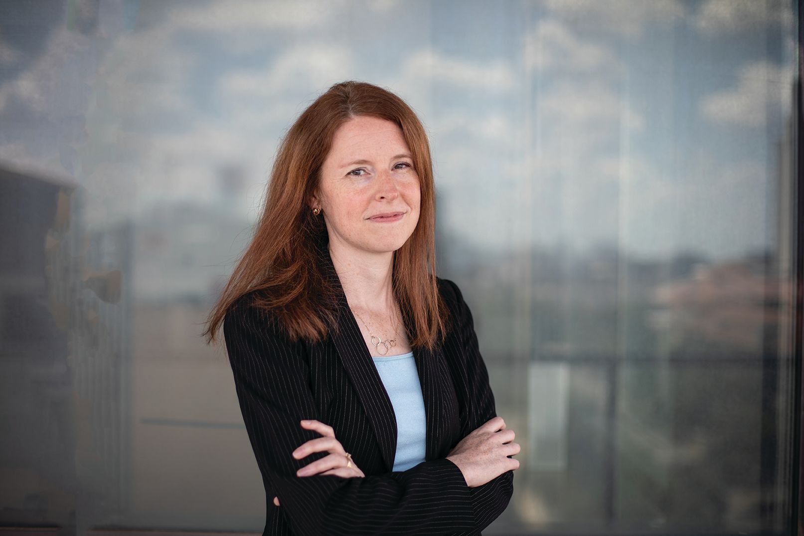 portrait of professor talia stroud posing with her arms crossed wearing a suit