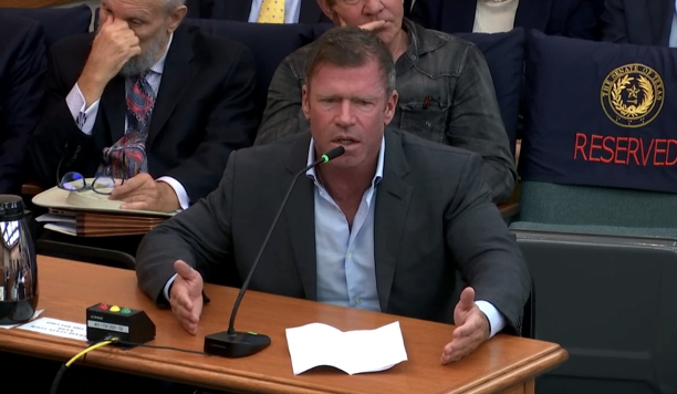 Taylor Sheridan sits at table giving testimony in the Texas State Legislature