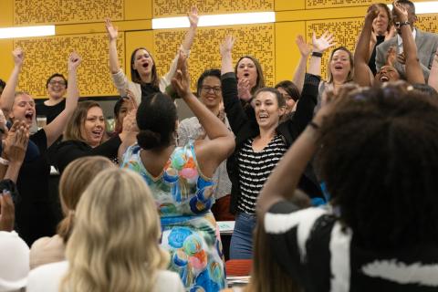 A group of people celebrating with their hands in the air.