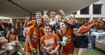A group of Moody College students wearing burnt orange at the CommUnity event in August 2024.