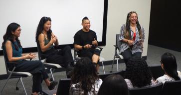 Professor PJ Raval speaks on a panel with three other professionals and this photo depicts all of them laughing together in an audiorium