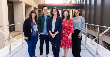 maya henry standing on the bridge with her staff and research assistants 