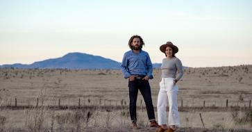 Maisie Crow and husband Max Kabat standing outside in West Texas, where they own a newspaper. 