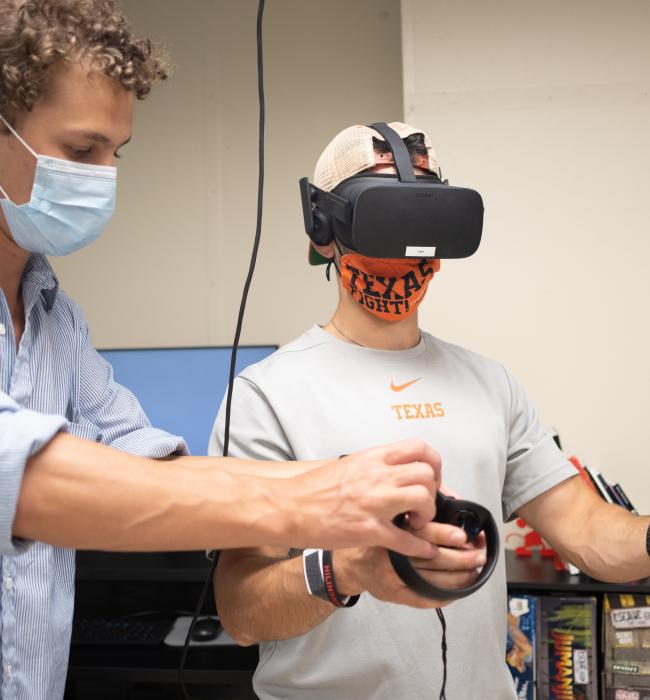 Image of student in VR headset with help from another student