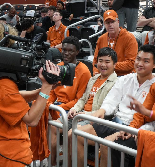 student videographer filming fans