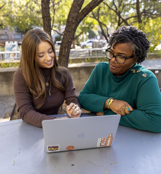 Student with professor looking at laptop