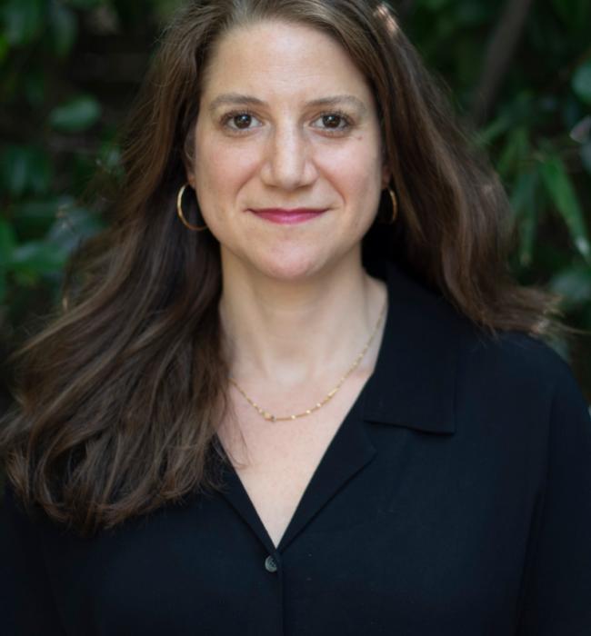 Sarah Spitz standing in front of greenery