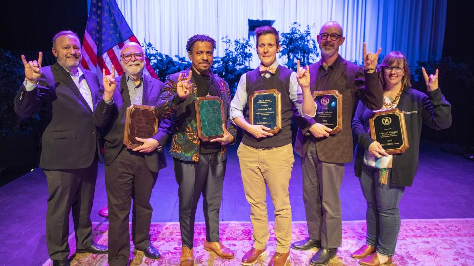 A group of college faculty and staff receive awards.