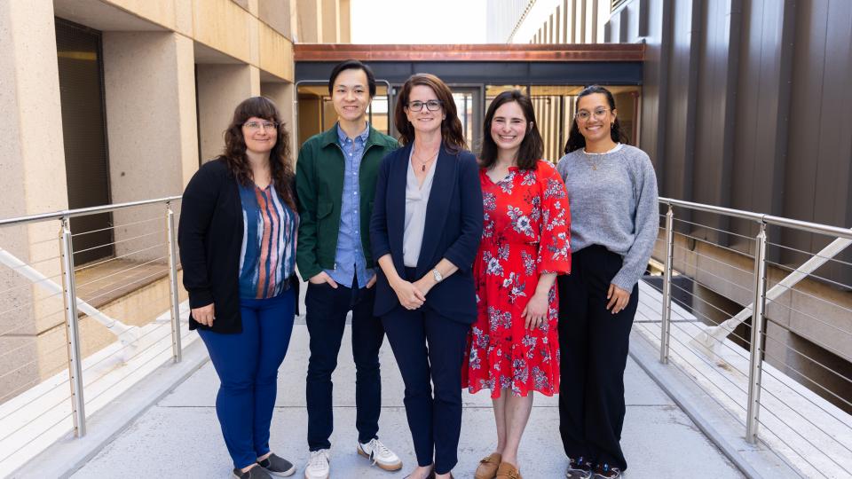 maya henry standing on the bridge with her staff and research assistants 
