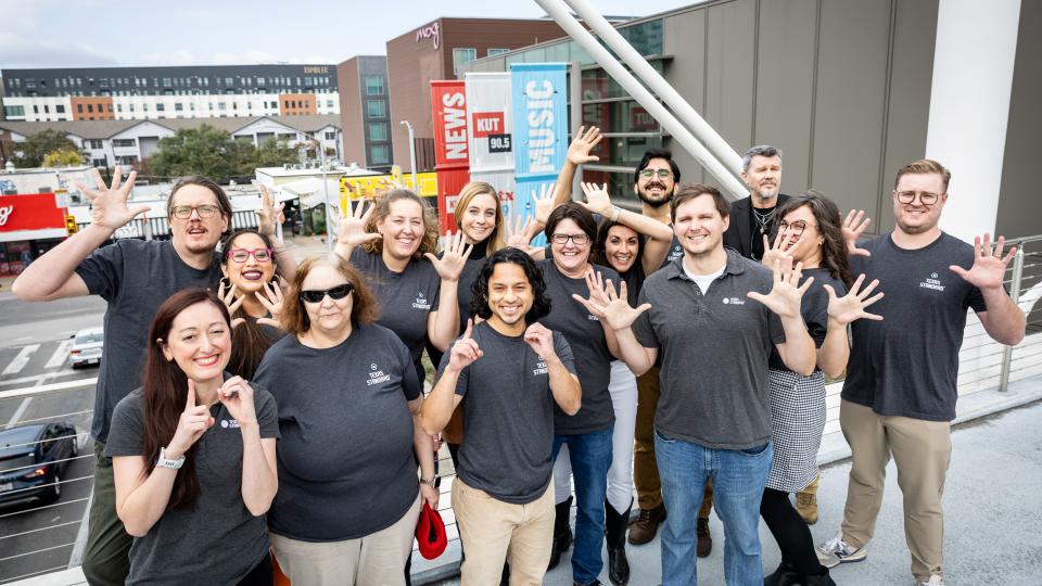 group photo of texas standard staff standing on the moody bridge celebrating 10 years