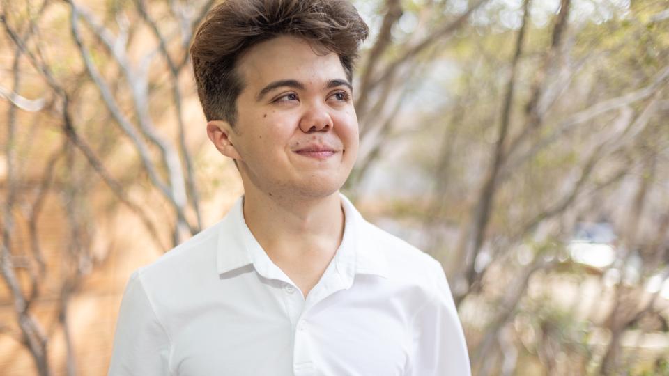 rtf student gregory weston looking up outside of DMC in white shirt