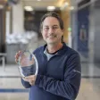 Mark Rogers holding award