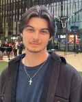 A young man standing in front of UT's Moody Center