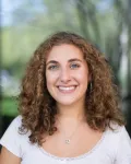 A portrait of a young woman with curly dark-blond hair.