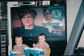 Two brothers watch their mom on TV.