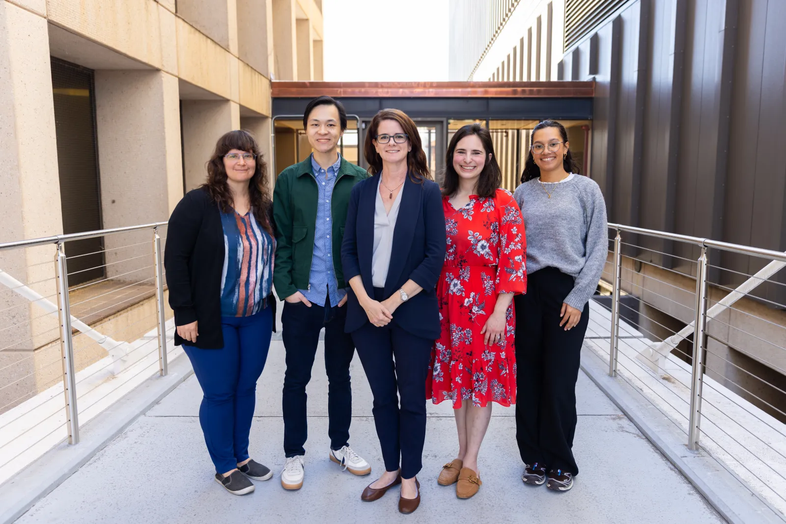 maya henry standing on the bridge with her staff and research assistants 