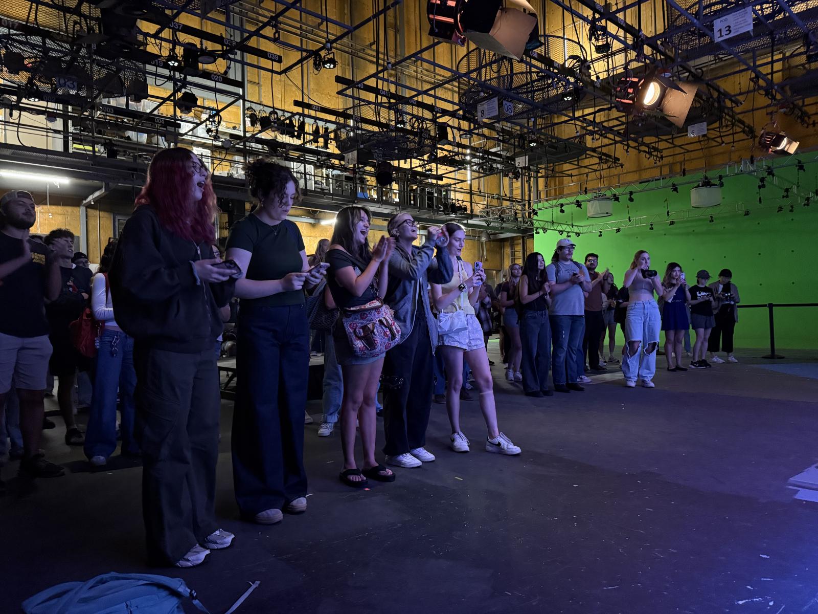 The image depicts students watching a concert in a studio.