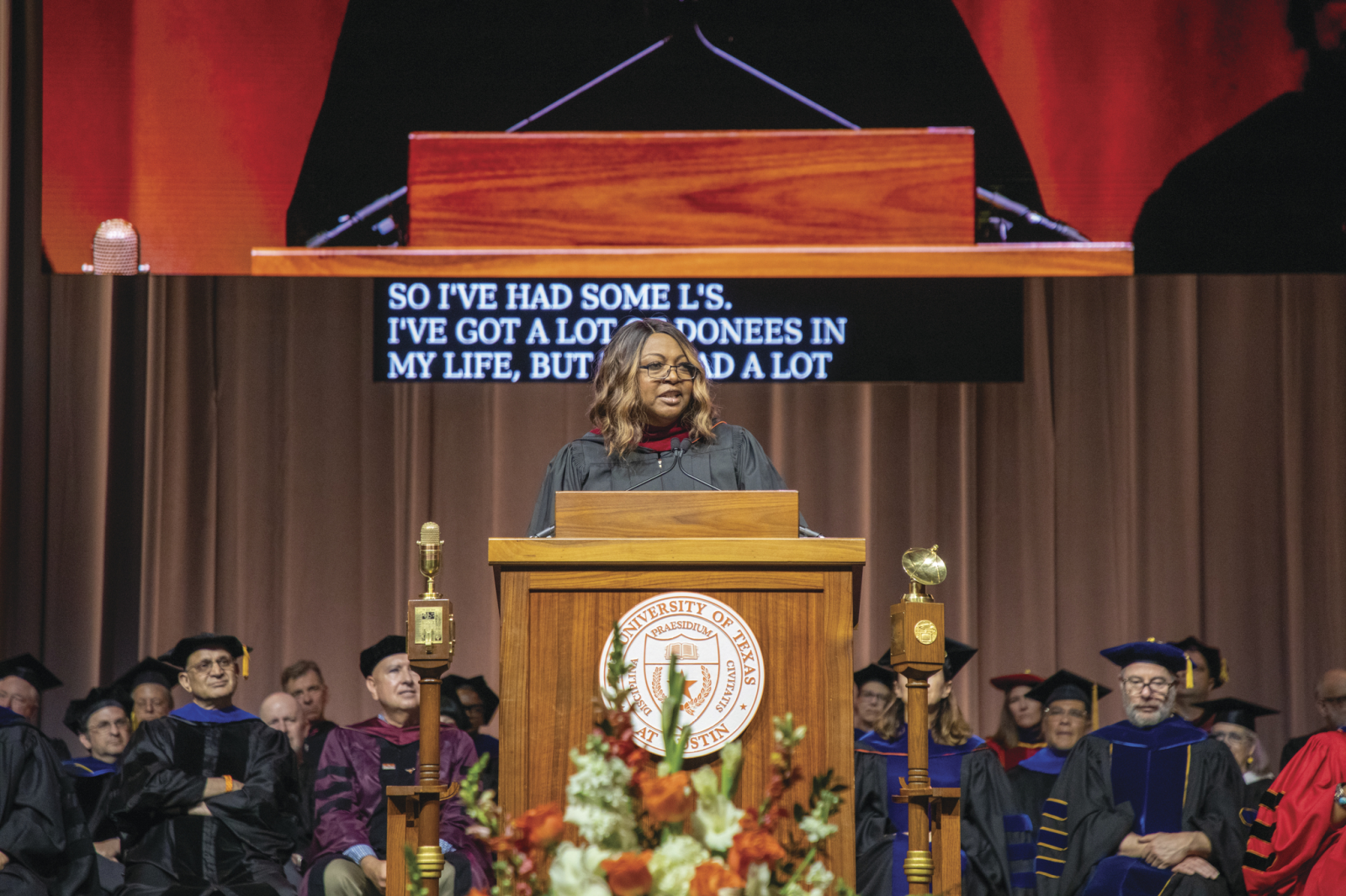 Fran Harris delivers the Moody College commencement address from a University of Texas podium.