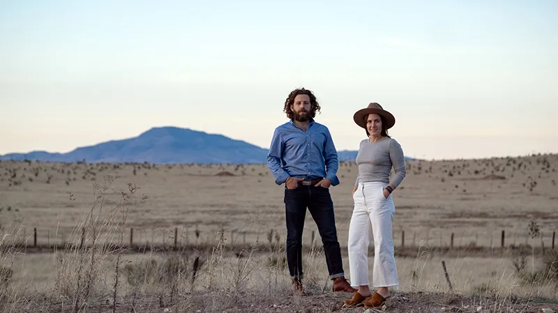 Maisie Crow and husband Max Kabat standing outside in West Texas, where they own a newspaper.