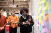 student writes on post-it note during brainstorm session