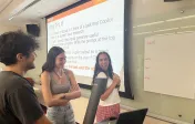 Image depicts students creating an anchor chart on the board