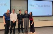 Five students stand and smile in front of a presentation slide titled "First Texas Bank"