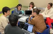 Six students sit in a circle to collaborate