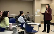 Dr. Stephens speaking animatedly with her hands as smiling students listen