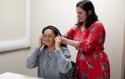 clinician helping patient with earphones