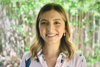 Headshot of Paloma Gray, Sr. Program Coordinator for the Center for Health Communication. A woman smiling with dark blonde hair, gold earrings, a gold necklace, and wearing a pale pink button down shirt with floral print.
