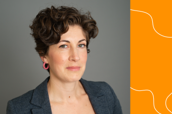 Headshot of Lara O'Toole, Sr. Program Coordinator at the CHC. White woman with short, curly brown hair wearing a dark gray blazer and multicolored tank top in front of a gray background