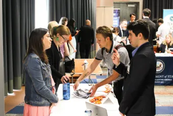 Recruiter speaks with student at a booth