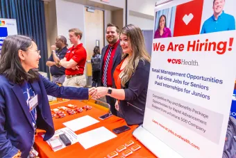 Recruiter shakes hands with student