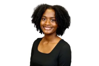 Student headshot, dark hair and dark shirt in front of white background