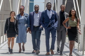group of college-aged individuals walking on a bridge