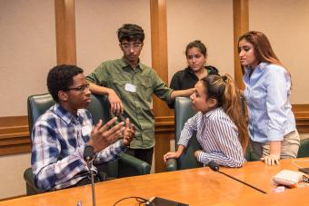 Group of students talking at a desk
