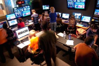 People in a dark computer room looking at the news and statistics about the news