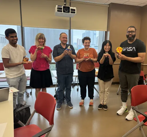 The image depicts a group presenting clay projects.