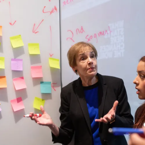 Professor and students working on white board