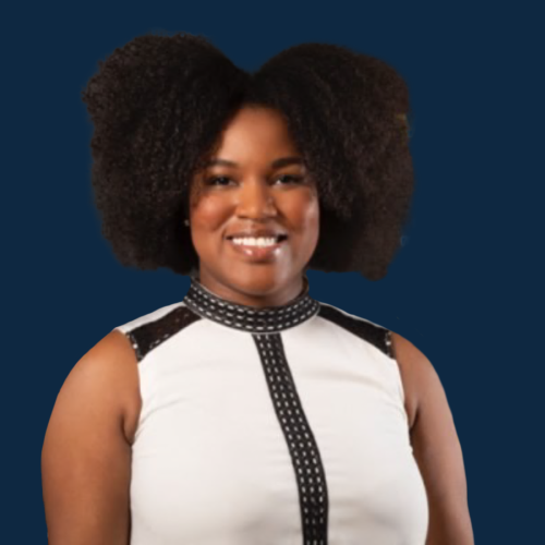 Woman smiling for her headshot in front of dark blue background