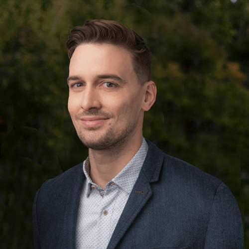 Man smiles at the camera for his headshot
