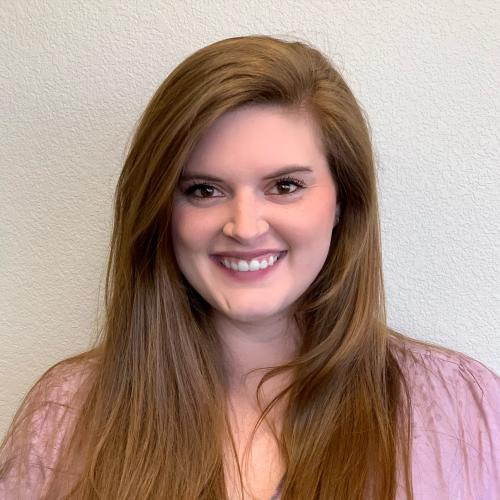 woman smiles at the camera for her headshot