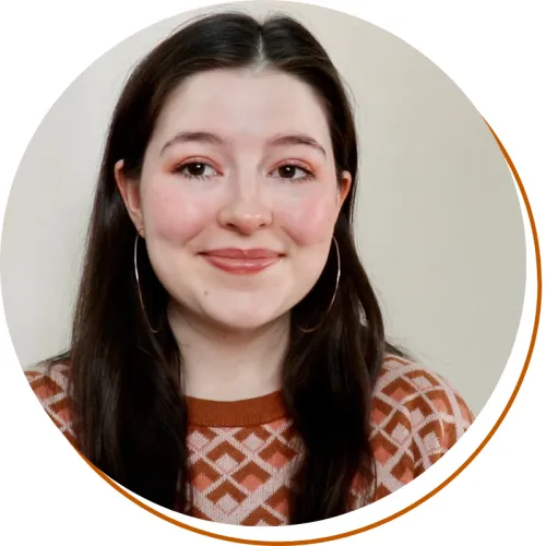 Morgan Stone Headshot Morgan Stone Headshot, shoulders up, long dark hair, earrings, and orange patterned sweater