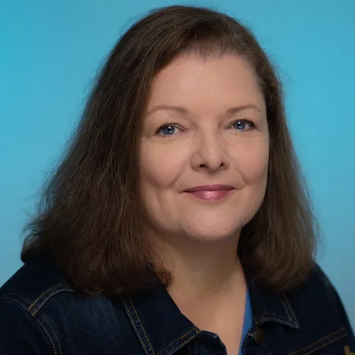 A portrait of a woman with shoulder-length brown hair.
