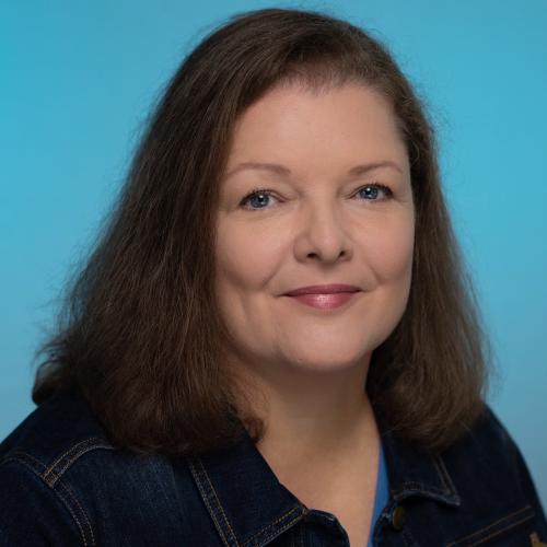 A portrait of a woman with shoulder-length brown hair.
